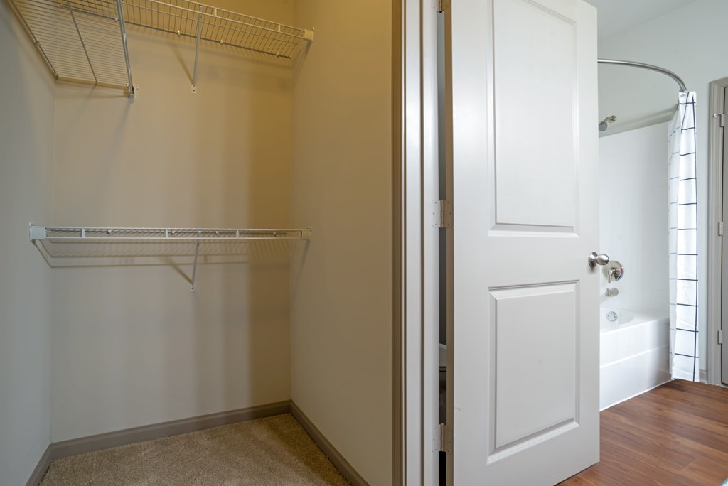 A white closet with a white door and a white towel hanging on the door.